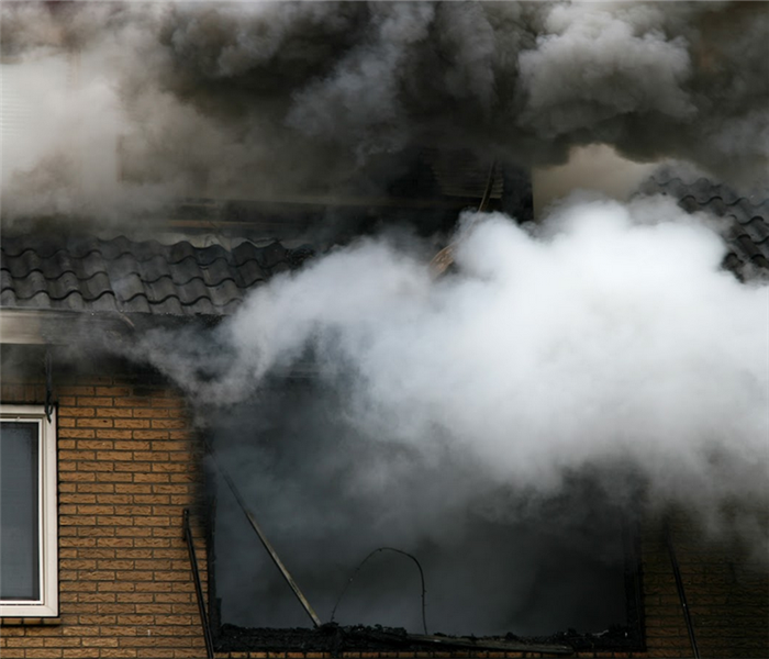 a house on fire with smoke billowing from its windows