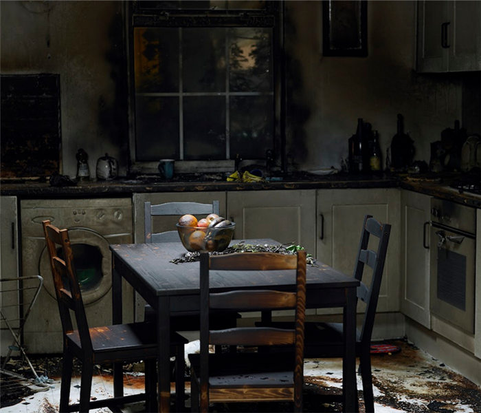 a fire damaged kitchen with soot covering the furniture
